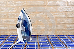 New modern electric steam iron on ironing board