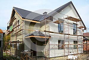 New modern house building home. Roof construction. Metal chimney. Insulated and plastered facade. Metal House roof. photo