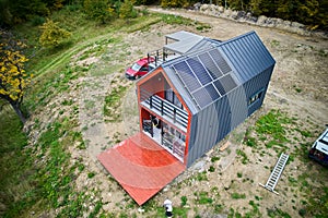 New modern house cottage with solar photovoltaic panel system on roof. Aerial view.