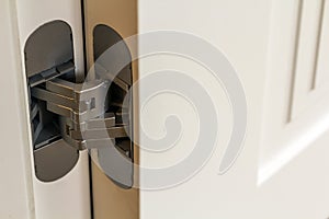 New modern metal door hinges on white wooden doors