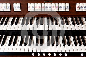 New modern pipe organ keyboards front view. Simple double electronic instrument keyboard seen from above, frontal shot, closeup