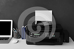 New modern printer, laptop and office supplies on white table