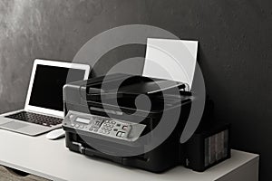 New modern printer and laptop on white table