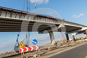 New modern road highway bridge overpass contruction site overhead view with heavy industrial machinery and blue sky on