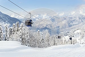 New modern spacious big cabin ski lift gondola against snowcapped forest tree and mountain peaks covered in snow