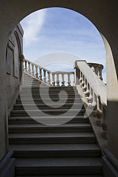 new modern staircase inside the building leads up. There are stone steps. The walls of the tunnel are white granite with railings