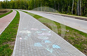 New modern tile sidewalk with chalk painted flowers near a road under construction