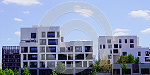 New modern white facade line building with balcony and terrace in blue sky