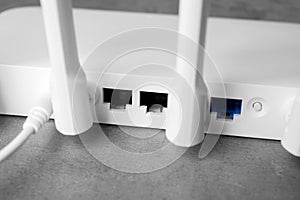 New modern Wi-Fi router on grey table, closeup