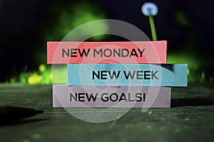 New Monday, New Week, New Goals! on the sticky notes with bokeh background