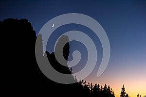 New moon over the mountains ,silhouette of tree and mountains after sunset ,twilight