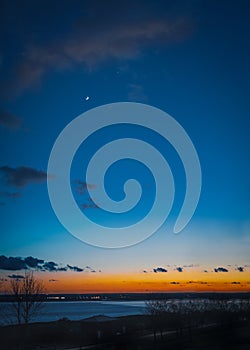 New moon and venus over Pegwell Bay just after sunset when the sky is a Depp blue with an intense orange and red glow