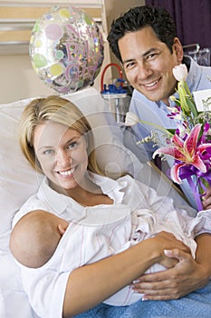 New mother with baby and husband in hospital