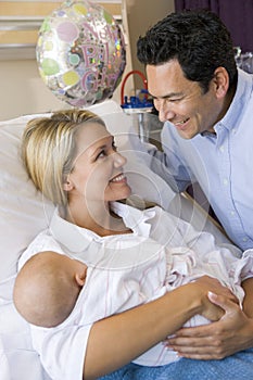 New mother with baby and husband in hospital