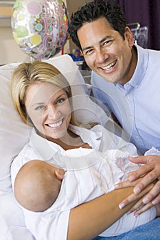 New mother with baby and husband in hospital