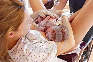 New mother holding her newborn child moments after labor