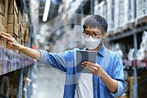 New Normal Asian men, staff, product wearing face mask. counting Warehouse Control Manager Standing, counting and inspecting