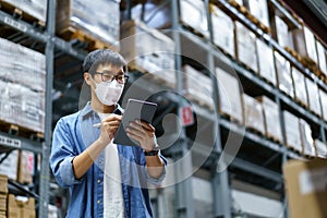 New Normal Asian men, staff, product wearing face mask. counting Warehouse Control Manager Standing, counting and inspecting