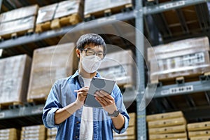 New Normal Asian men, staff, product wearing face mask. counting Warehouse Control Manager Standing, counting and inspecting