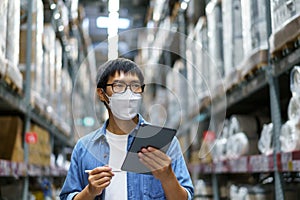 New Normal Asian men, staff, product wearing face mask. counting Warehouse Control Manager Standing, counting and inspecting