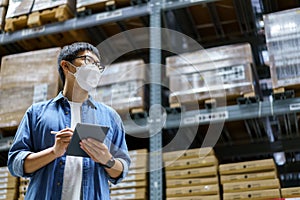 New Normal Asian men, staff, product wearing face mask. counting Warehouse Control Manager Standing, counting and inspecting