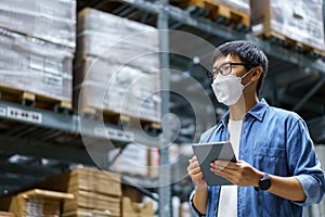 New Normal Asian men, staff, product wearing face mask. counting Warehouse Control Manager Standing, counting and inspecting