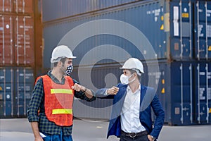 New normal concept,Engineer worker greeted by bumping elbow for distance between people wearing mask and helmet in the factory or