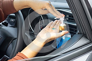 New normal lifestyle concept background with woman applying hand sanitizer alcohol gel to clean her hand before driving a car photo