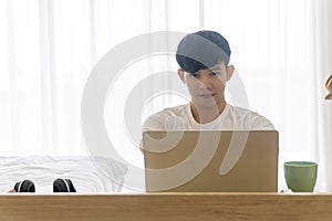 New normal lifestyle technology concept. Handsome freelance or employee young man wear casual clothing using laptop working at