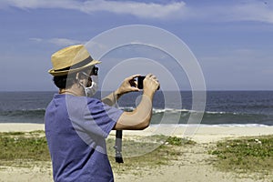 The new normal - middle-aged man takes a picture of the beach