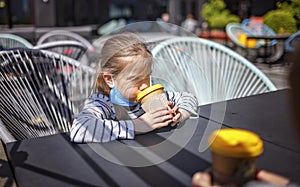 New normal reality, stay safe in street cafe, kids with medical mask waiting for breakfast