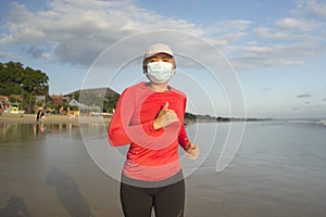 New normal running workout with face mask - attractive and happy middle aged woman on her 40s or 50s doing post quarantine jogging