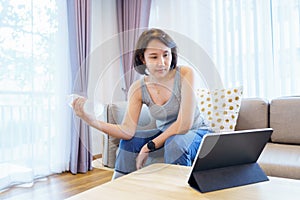 New normal Training At Home An Asian woman, aged 30-35, with brown skin, Home exercise. exercising in living room