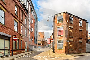 New and old brick buildings along a cobbled in a oric city centre on a sunny summer day