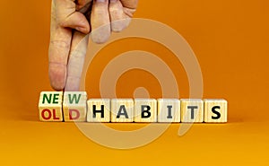 New or old habits symbol. Businessman turns wooden cubes and changes words `old habits` to `new habits`. Beautiful orange tabl