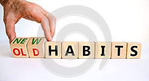 New or old habits symbol. Businessman turns wooden cubes and changes words `old habits` to `new habits`. Beautiful white table