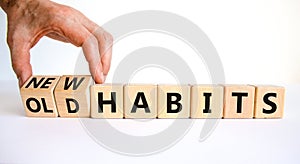 New or old habits symbol. Businessman turns wooden cubes and changes words `old habits` to `new habits`. Beautiful white table