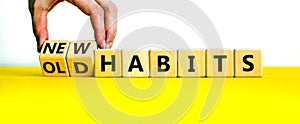 New or old habits symbol. Businessman turns wooden cubes and changes words `old habits` to `new habits`. Beautiful yellow tabl