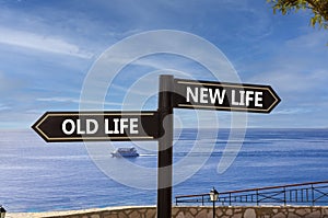 New or old life symbol. Concept word New life Old life on beautiful signpost with two arrows. Beautiful blue sea sky with clouds