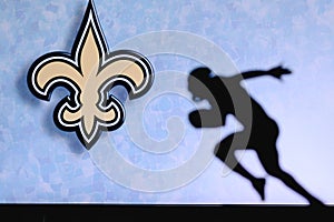 New Orleans Saints. Silhouette of professional american football player. Logo of NFL club in background, edit space