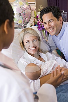 New parents with baby talking to doctor