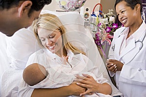 New parents with baby talking to doctor and smilin