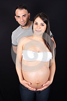 New parents looking at belly of pregnant mother in love