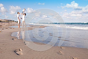 New Parents Play with Baby on the Beach photo