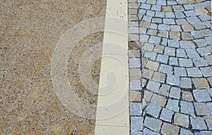 A new park path made of irregular cubes, folded with a side channel for draining water from the road surface. granite stones of