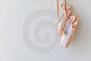New pastel beige ballet shoes with satin ribbon isolated on white background. Ballerina classical pointe shoes for dance