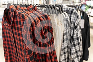 new plaid shirts with short sleeves on a hanger in a clothing store