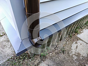 New plastic downpipe on an old house sheathed with new siding