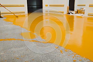 New polished concrete floor covered with a layer of yellow epoxy resin