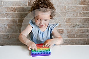 New popular silicone popit toy, baby is playing with it. Development of fine motor skills